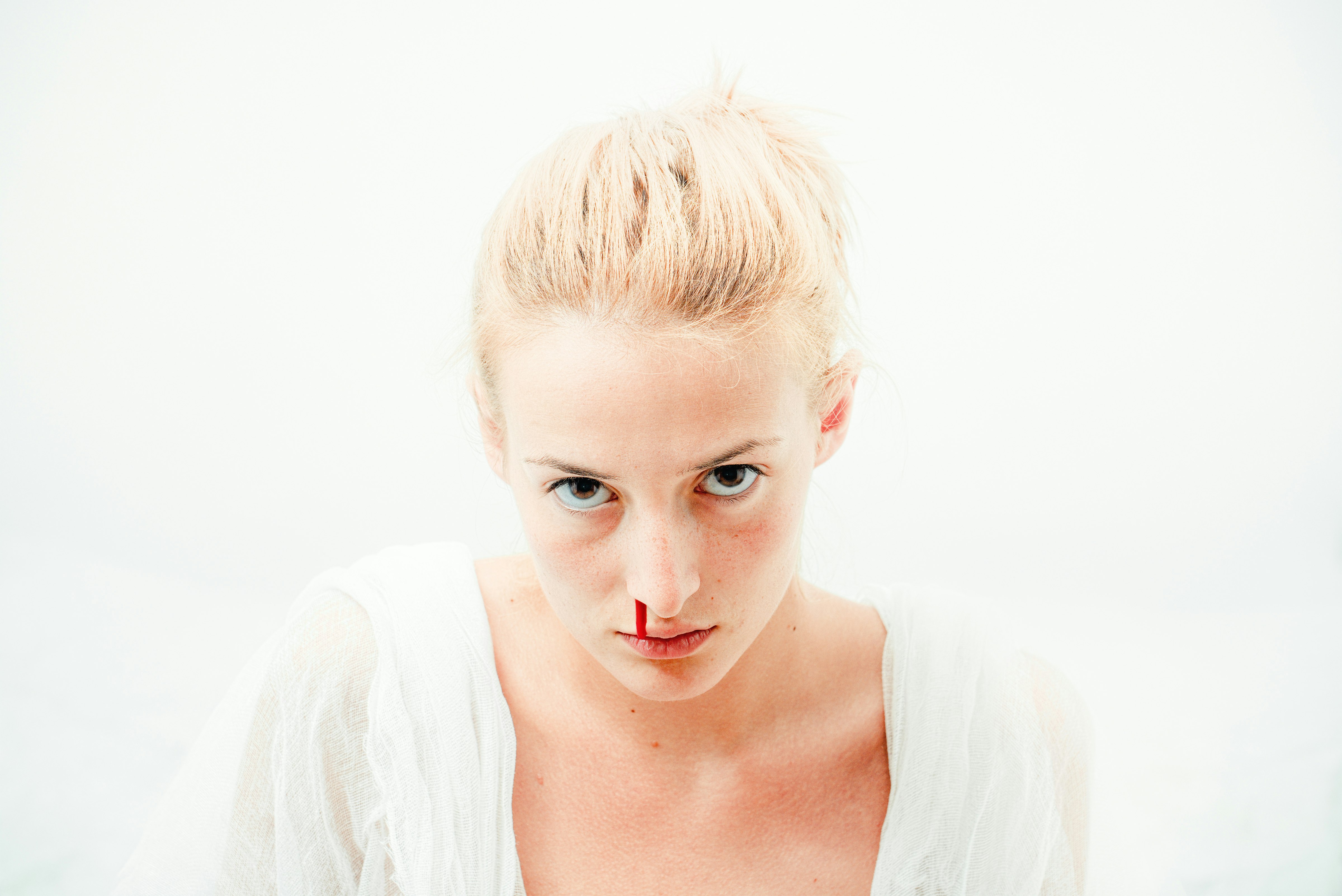 woman's bleeding nose with white background